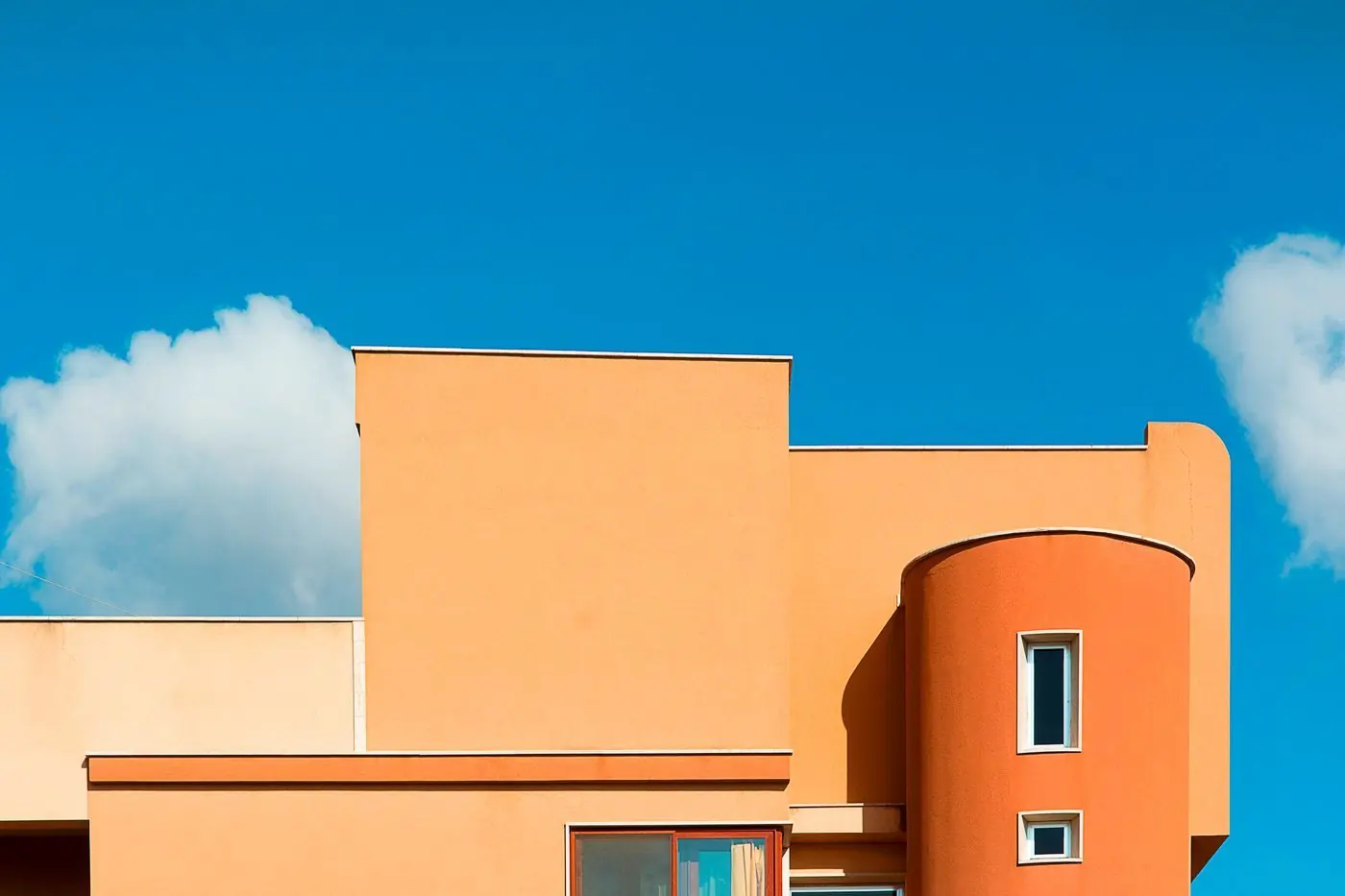 Gestucte gevel van een modern huis tegen een blauwe lucht